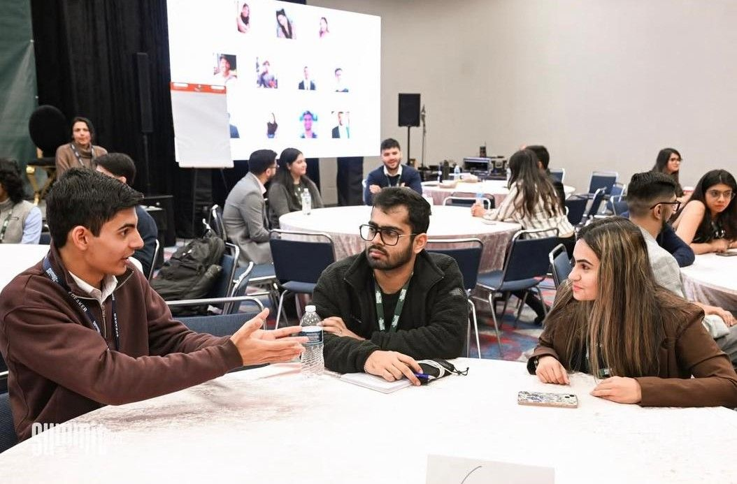 Isaiah Sidi speaking with an attendee at the IPN Summit
